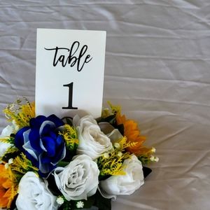 25 table center pieces. Made with navy blue & white roses & sunflowers